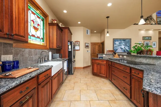a large kitchen with stainless steel appliances granite countertop a sink and cabinets