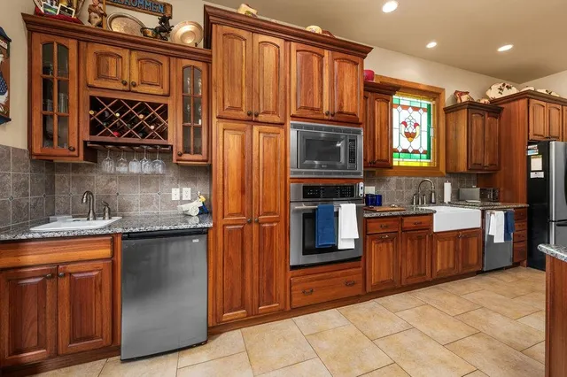 a kitchen with stainless steel appliances granite countertop a refrigerator and a sink