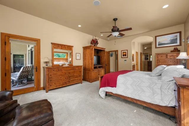 a spacious bedroom with a bed and ceiling fan