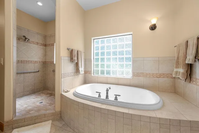 a white bath tub sitting in a bathroom next to a window
