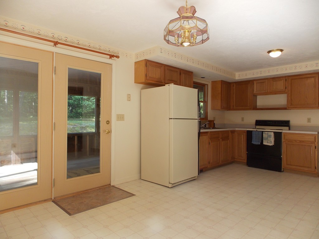 48 Simonds Hill Road Hubbardston, MA 01452 - Photo 8 of 25 a kitchen with a refrigerator a stove top oven and a glass table