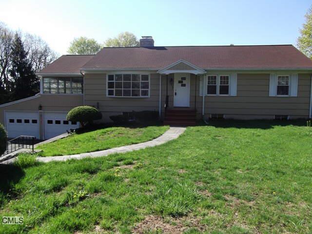 a front view of a house with a garden and yard