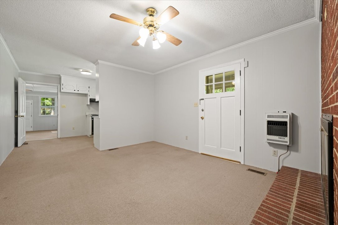 304 Shaw Road Honea Path, SC 29654 - Photo 11 of 39 This inviting space features comfortable carpeting, a kitchen pass-through, and a functional entry door.
