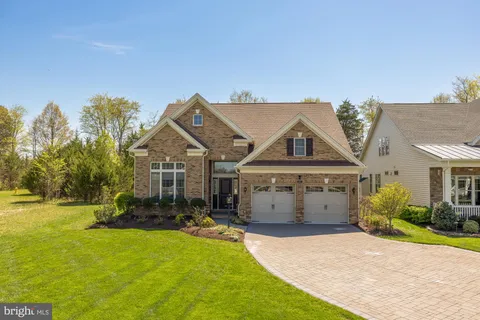 a front view of a house with a garden and yard