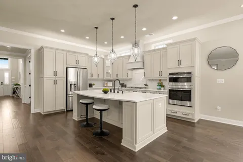 a kitchen with granite countertop a stove a sink dishwasher and cabinets with wooden floor