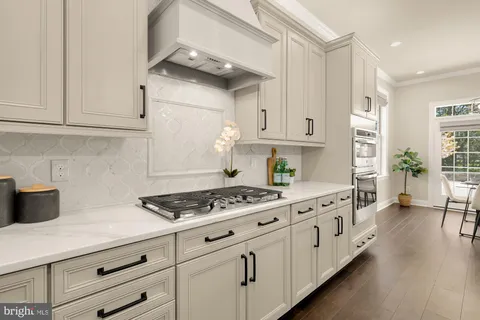 a large kitchen with kitchen island a stove a sink a center island a dining table and chairs