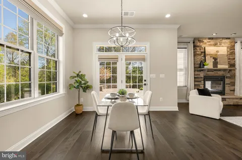 a dining room with furniture a chandelier and wooden floor