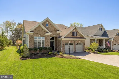 a view of a big house with a big yard and potted plants