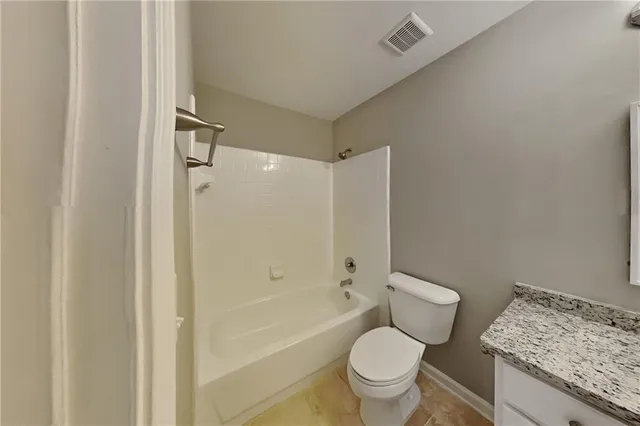 a white toilet sitting next to a bath tub