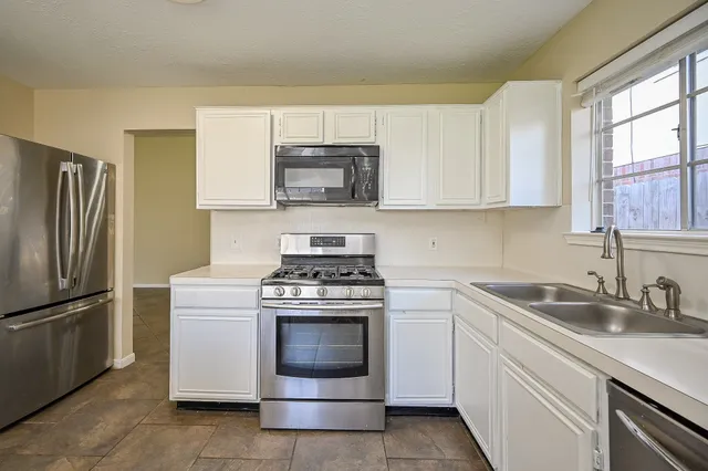 a kitchen with cabinets appliances and a sink