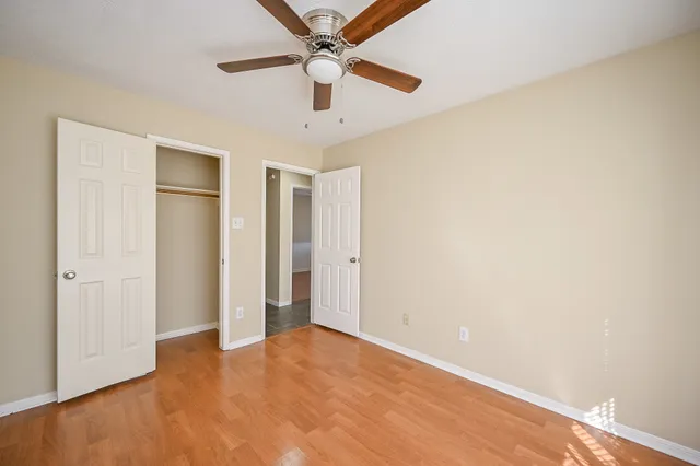 an empty room with a ceiling fan and a window