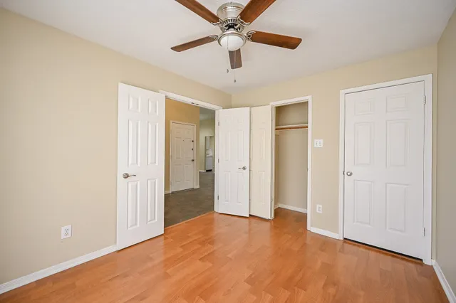a view of an empty room with window and a ceiling fan