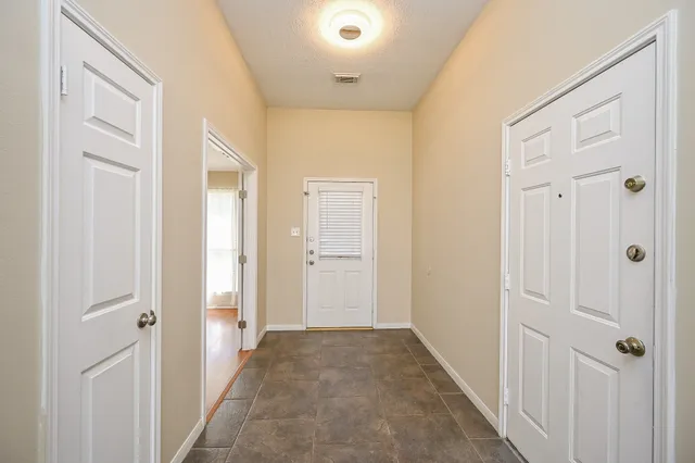 a view of a hallway with wooden floor and closet area