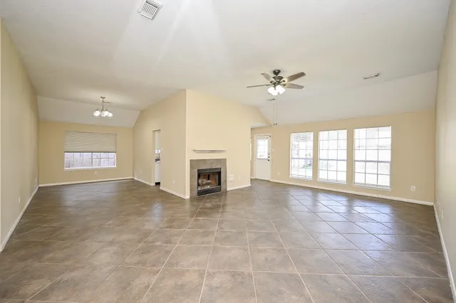 a view of an empty room with a fireplace and a window