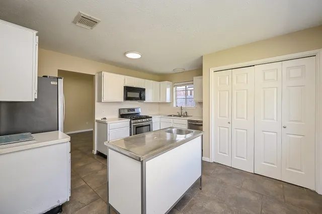 a kitchen with a refrigerator stove and sink