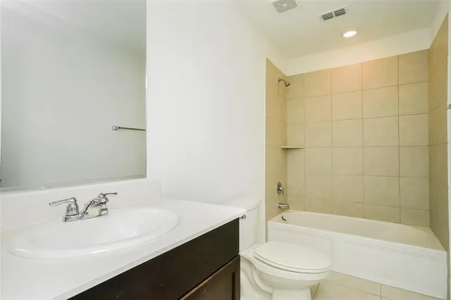 a bathroom with a bathtub shower sink vanity mirror and toilet