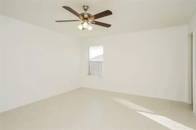 an empty room with a window and a fan