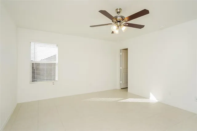 an empty room with wooden floor and ceiling fan