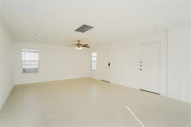 an empty room with chandelier fan