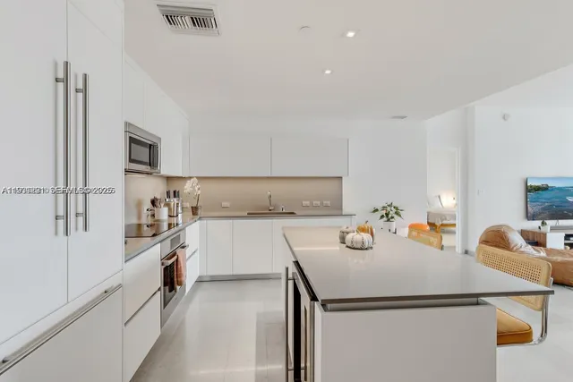 a kitchen that has a sink and a stove top oven
