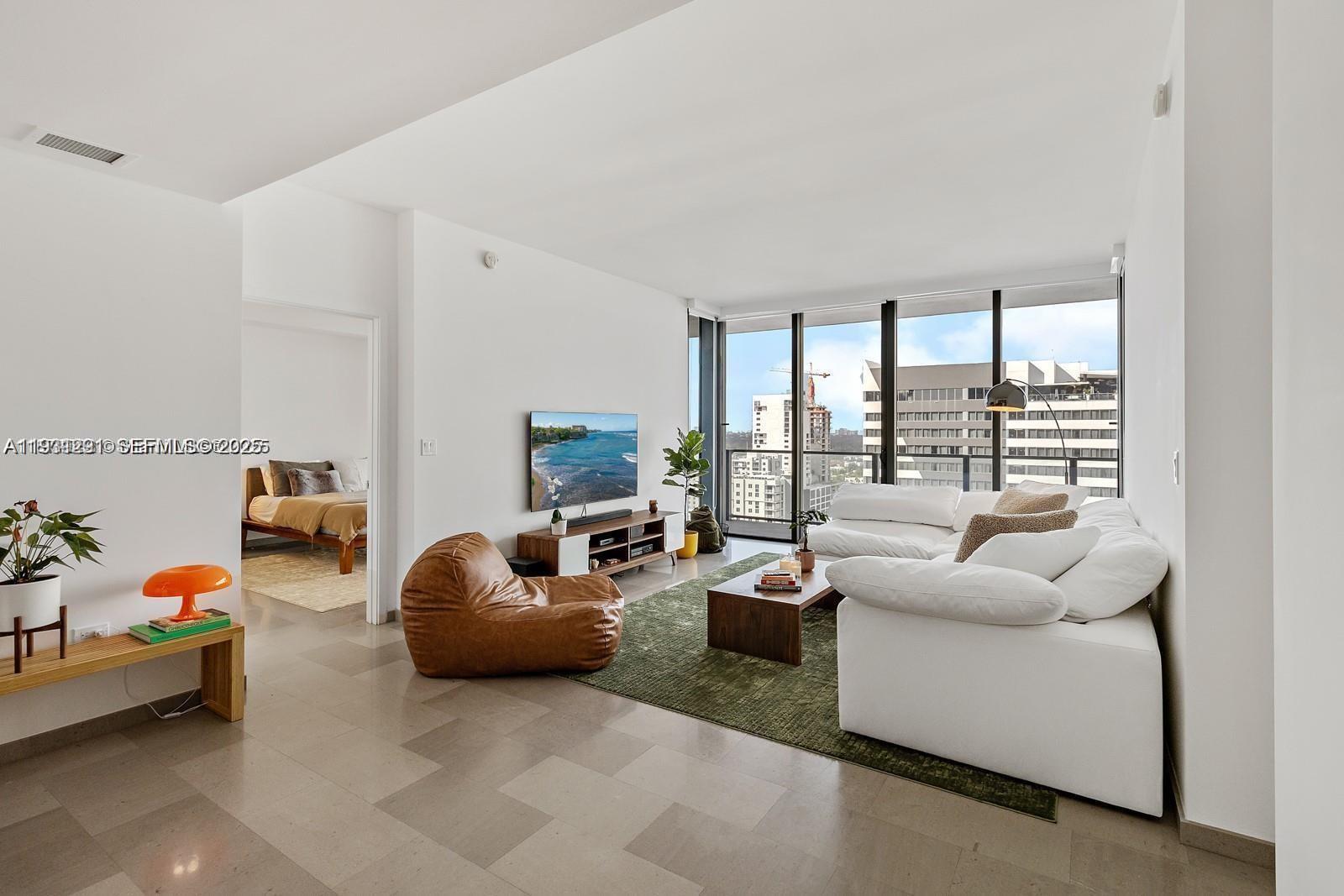 88 Southwest 7th Street, Unit 1710 Miami, FL 33130 - Photo 5 of 12 a living room with furniture and a large window