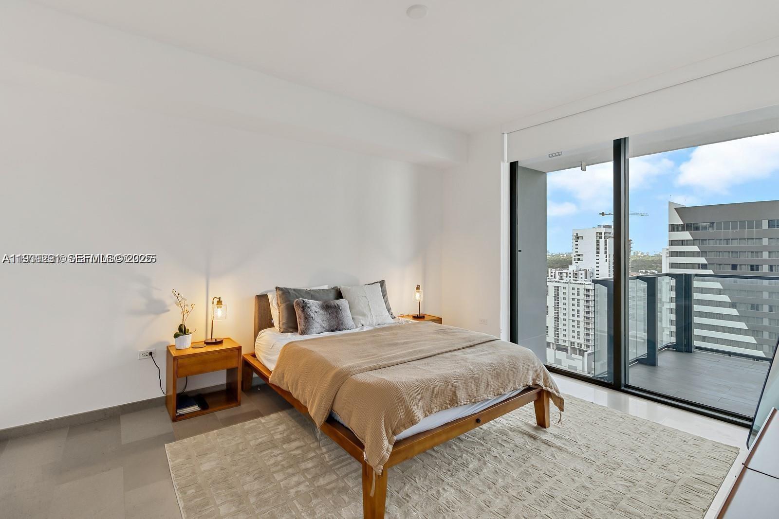 88 Southwest 7th Street, Unit 1710 Miami, FL 33130 - Photo 6 of 12 a bedroom with a bed and large mirror