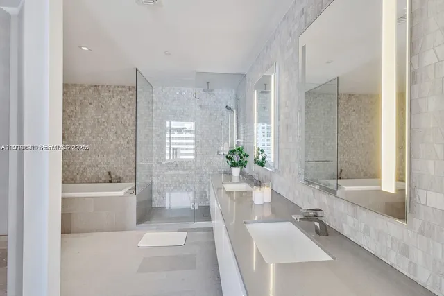 a bathroom with a tub a sink and a large mirror