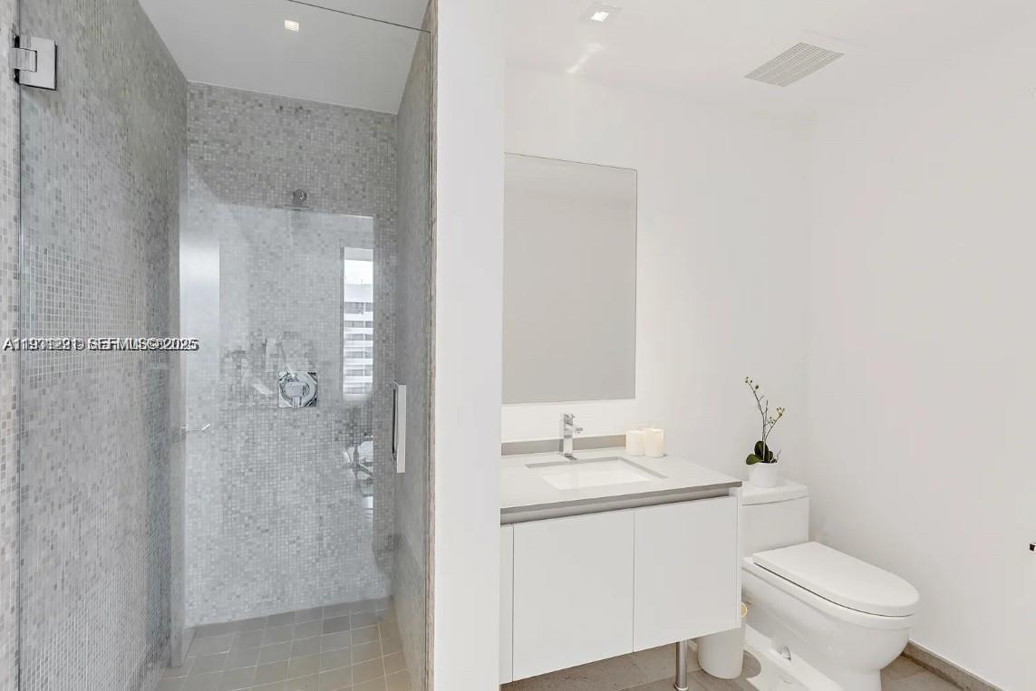 88 Southwest 7th Street, Unit 1710 Miami, FL 33130 - Photo 9 of 12 a bathroom with a granite countertop sink toilet and shower
