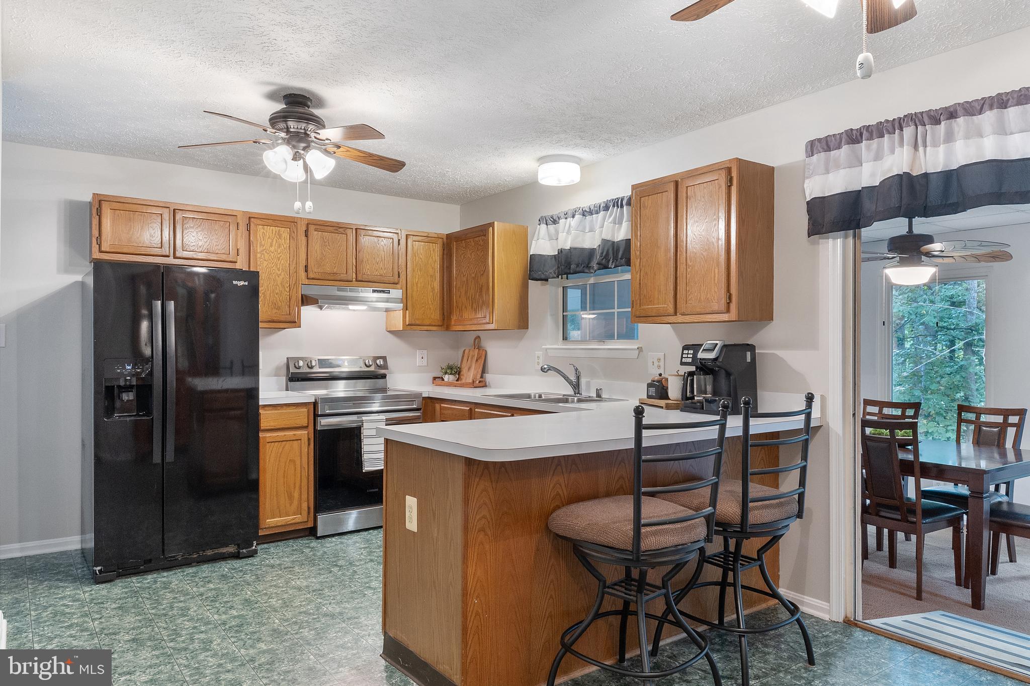 11316 Commanche Road Lusby, MD 20657 - Photo 8 of 68 a kitchen with stainless steel appliances granite countertop a refrigerator a sink a stove a dining table and chairs