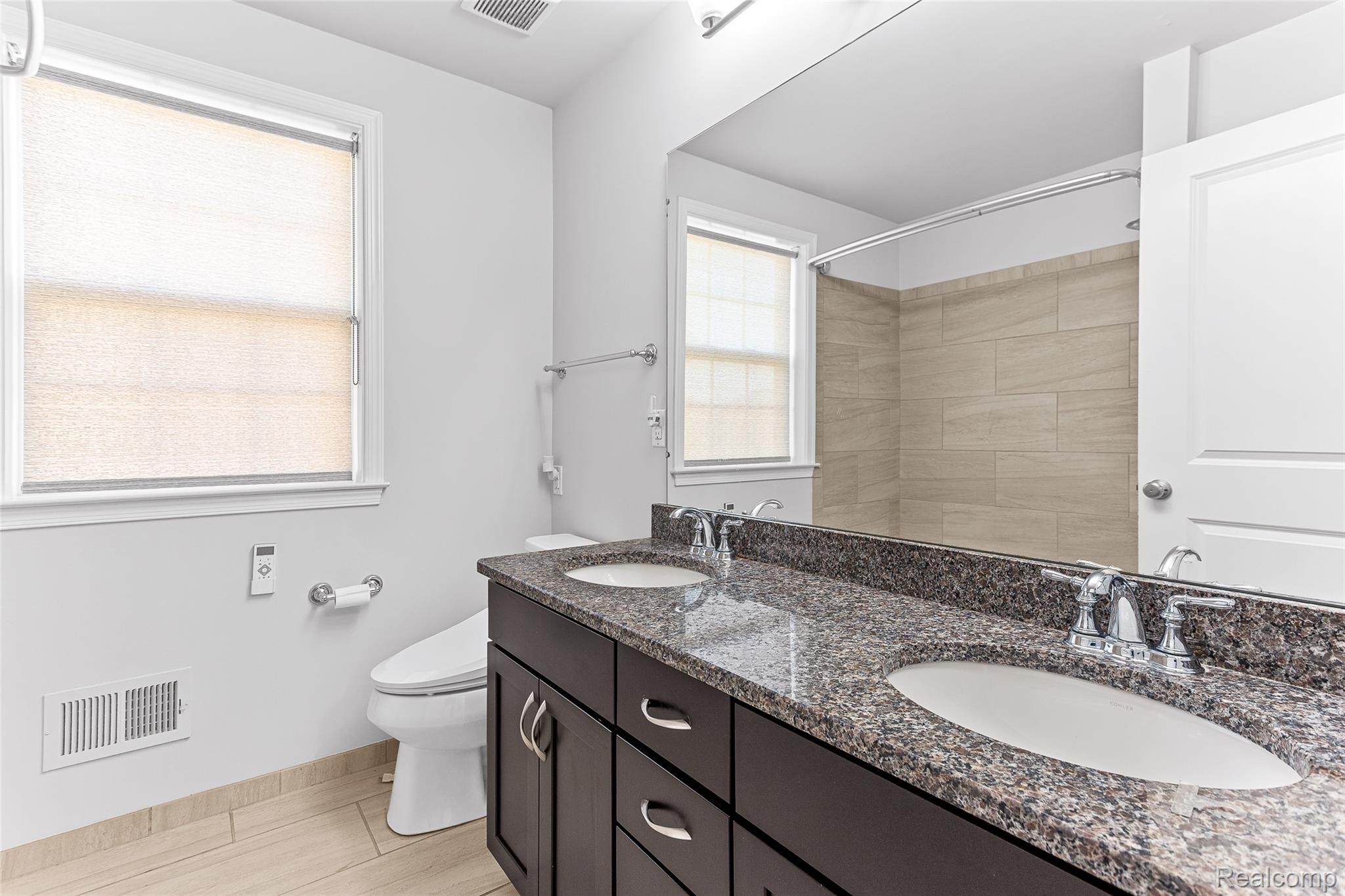 50873 Scarborough Road Canton, MI 48188 - Photo 14 of 25 Dual vanity with dark wood-finish cabinetry and speckled stone countertops
