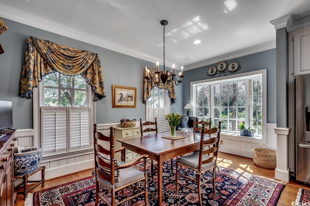 12 Chapin Circle Myrtle Beach, SC 29572 - Photo 15 of 39 Dining room with a notable chandelier, light wood-style flooring, ornamental molding, and wainscoting