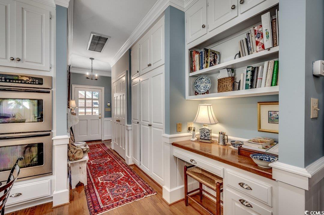 12 Chapin Circle Myrtle Beach, SC 29572 - Photo 18 of 39 Kitchen with visible vents, double oven, built in desk, and white cabinetry