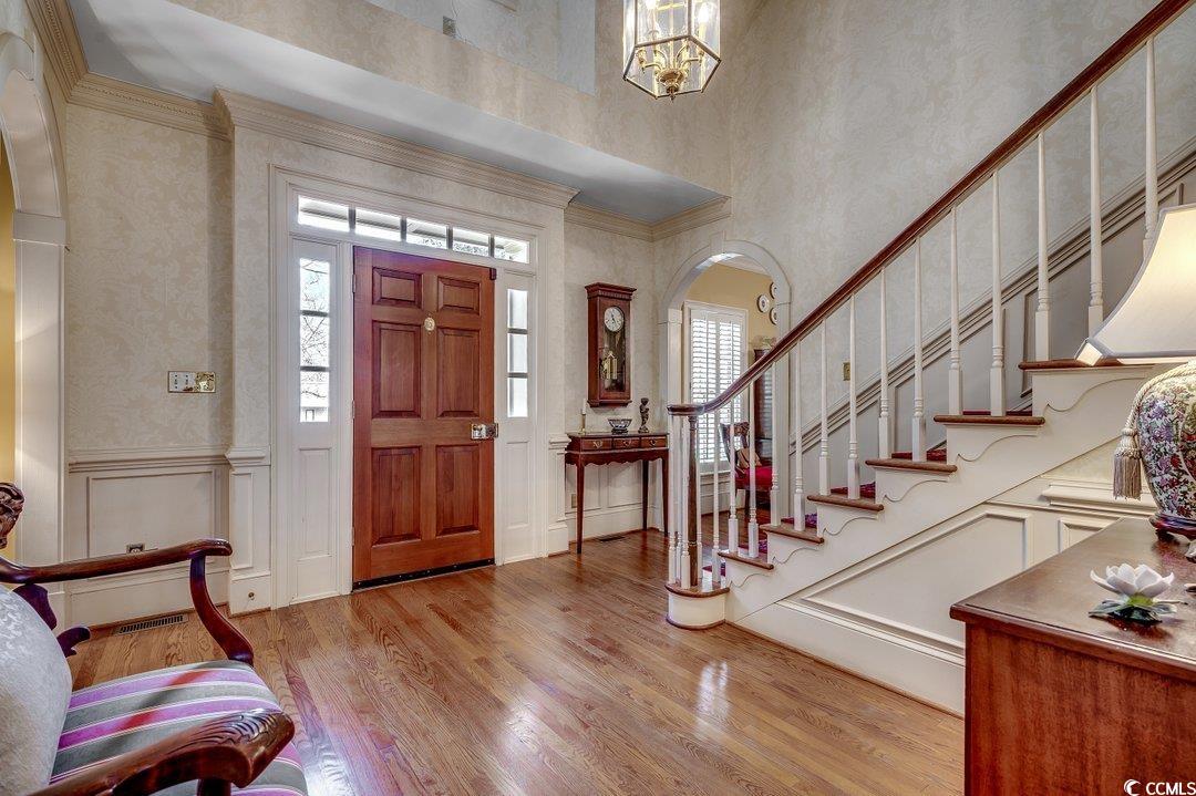 12 Chapin Circle Myrtle Beach, SC 29572 - Photo 3 of 39 Foyer entrance with wood finished floors, an inviting chandelier, arched walkways, ornamental molding, and a decorative wall