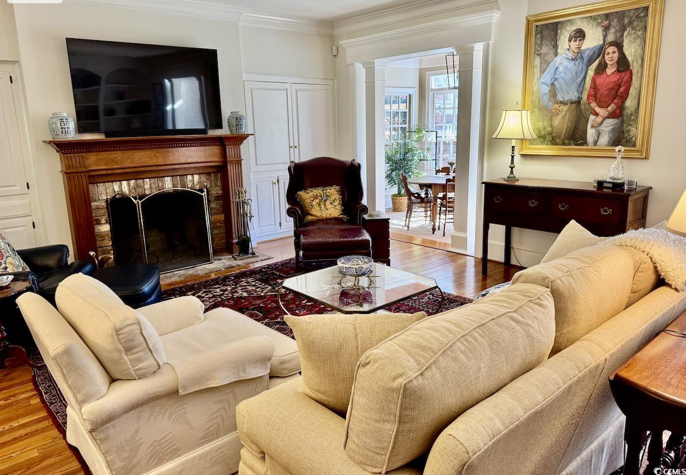 12 Chapin Circle Myrtle Beach, SC 29572 - Photo 36 of 39 Living area featuring decorative columns, crown molding, wood finished floors, and a fireplace with raised hearth
