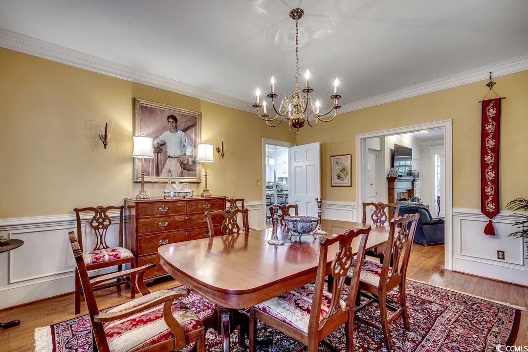 12 Chapin Circle Myrtle Beach, SC 29572 - Photo 5 of 39 Dining area featuring a wainscoted wall, wood finished floors, a chandelier, and ornamental molding