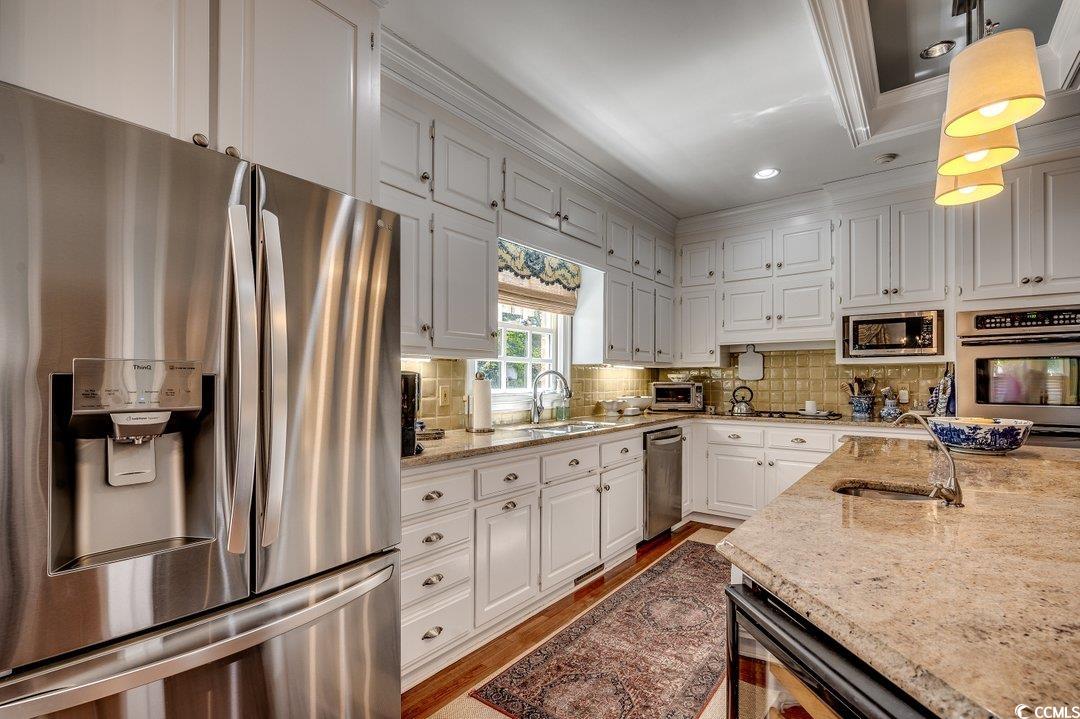 12 Chapin Circle Myrtle Beach, SC 29572 - Photo 6 of 39 Kitchen with a sink, stainless steel appliances, light stone counters, and backsplash