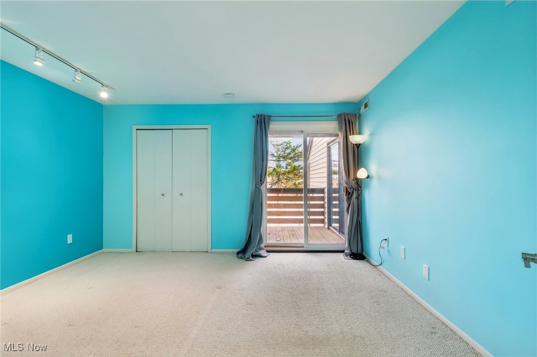 3484 Mayfield Road, Unit 3426 Cleveland Heights, OH 44118 - Photo 21 of 33 Unfurnished bedroom featuring carpet flooring, baseboards, access to exterior, track lighting, and a closet