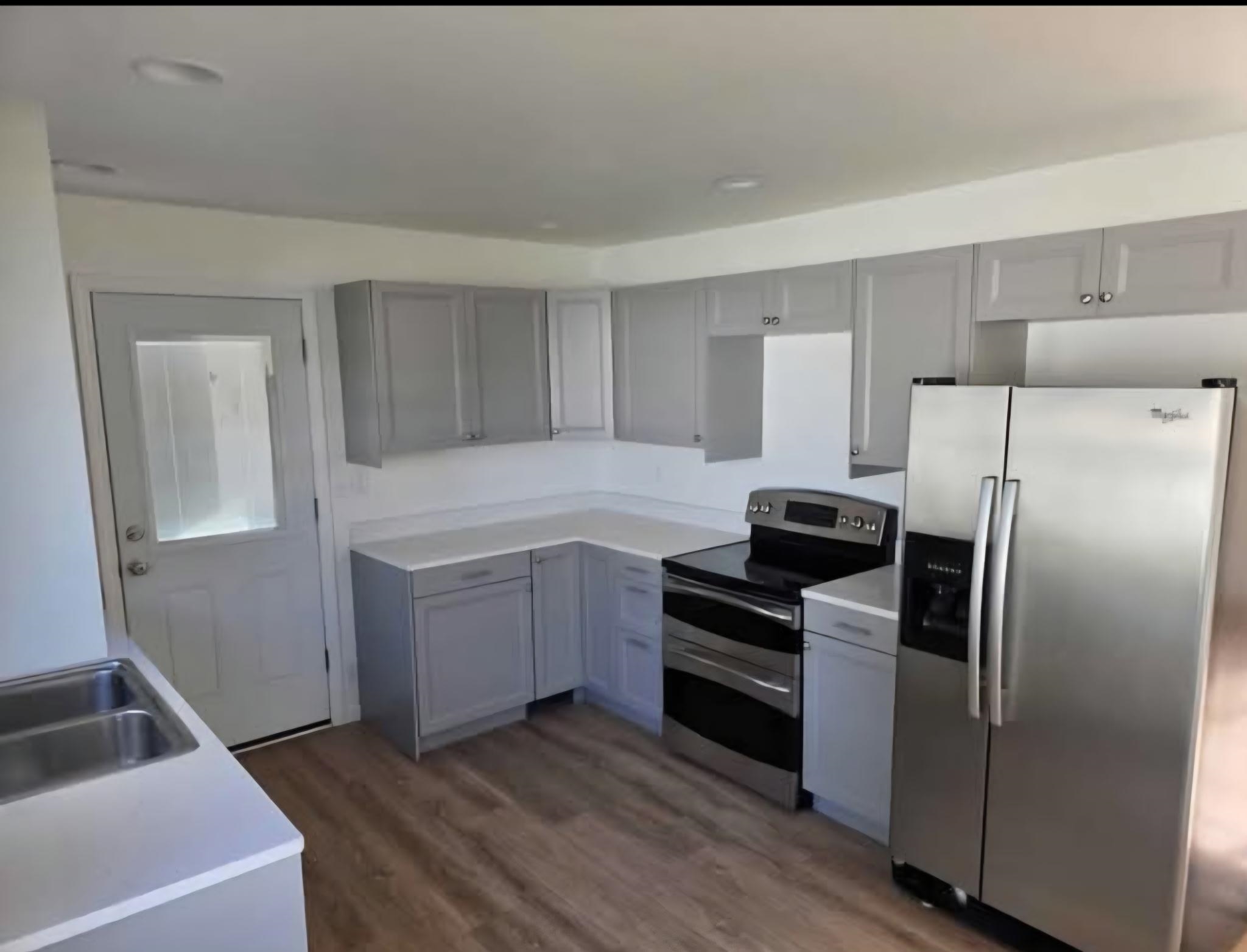 704 Spruce Street Savanna, IL 61074 - Photo 3 of 19 a kitchen with a refrigerator sink and cabinets