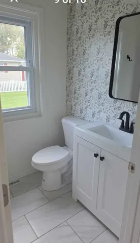 a bathroom with a toilet sink and mirror