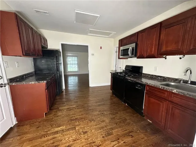 a kitchen with stainless steel appliances granite countertop a stove a sink and a microwave