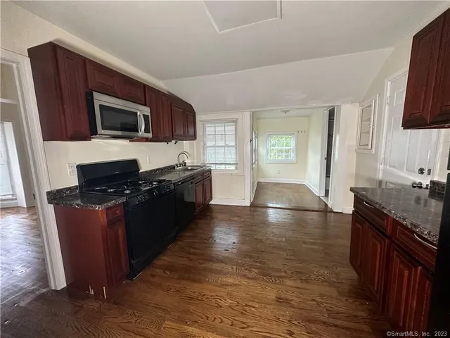a kitchen with granite countertop a stove top oven and sink