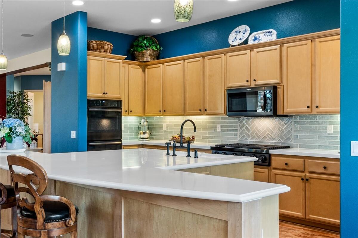 81836 Bowstring Circle La Quinta, CA 92253 - Photo 14 of 55 a kitchen with stainless steel appliances a dining table chairs microwave and sink