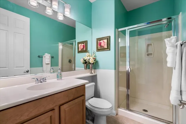 a bedroom with a bed a dresser and next to a window