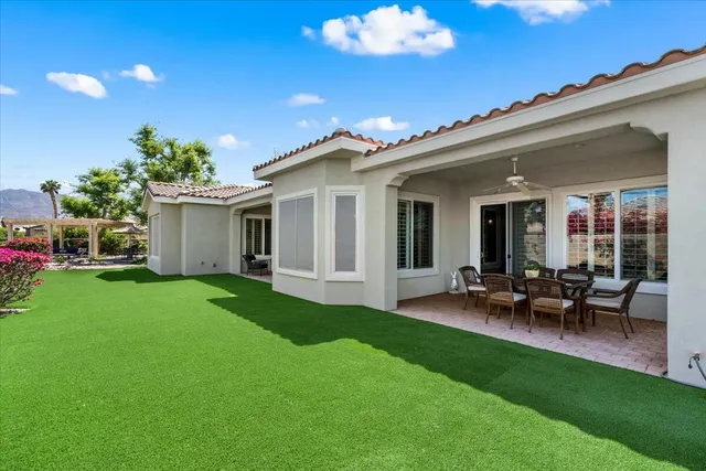 a view of a patio with table and chairs potted plants and large tree