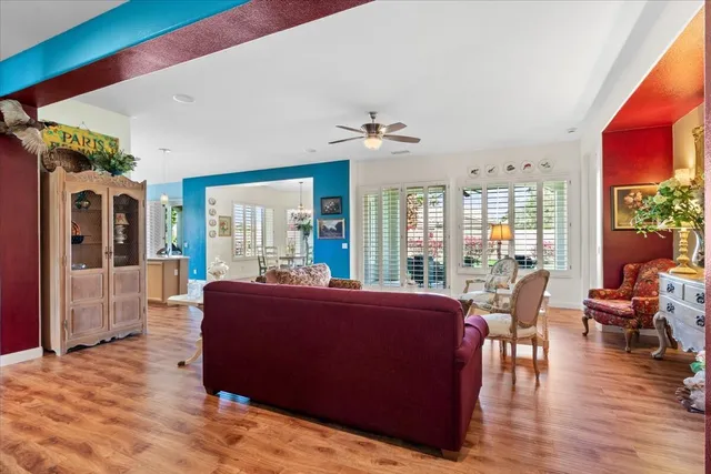 a living room with furniture large window and wooden floor
