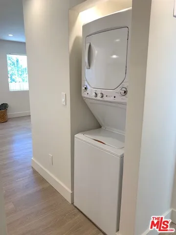 a utility room with wooden floor washer and dryer