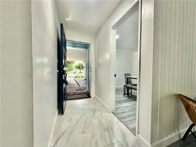 a view of a hallway with wooden floor a bedroom and a bed