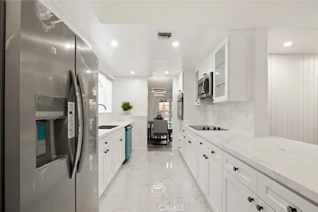 a kitchen with granite countertop a sink stainless steel appliances and cabinets