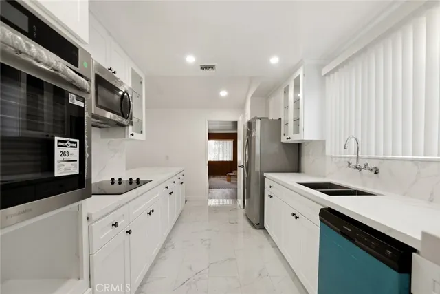 a kitchen with stainless steel appliances a refrigerator sink and cabinets