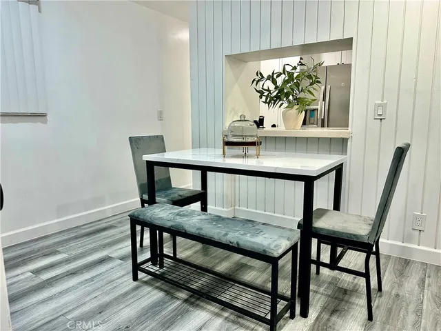 a view of a hallway with wooden floor a bedroom and a bed